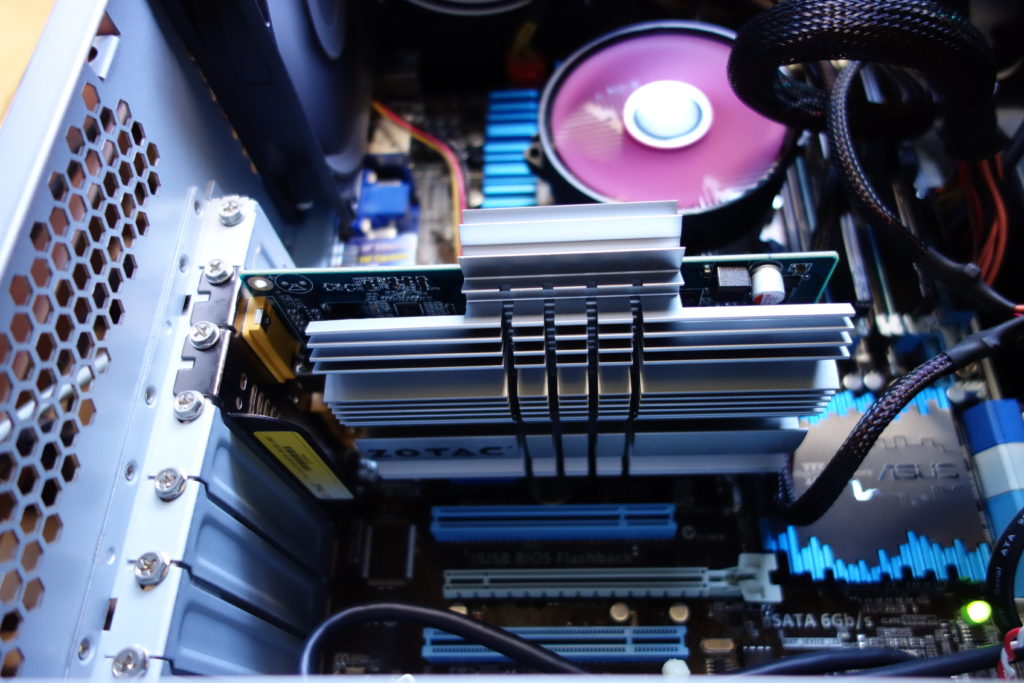 自作PCの内部を撮影した写真。 様々な部品やケーブルが見える。 写真中央にはファンレス ヴィデオ カードのGeForce GT 240 1GB ZONE Editionが写っている。