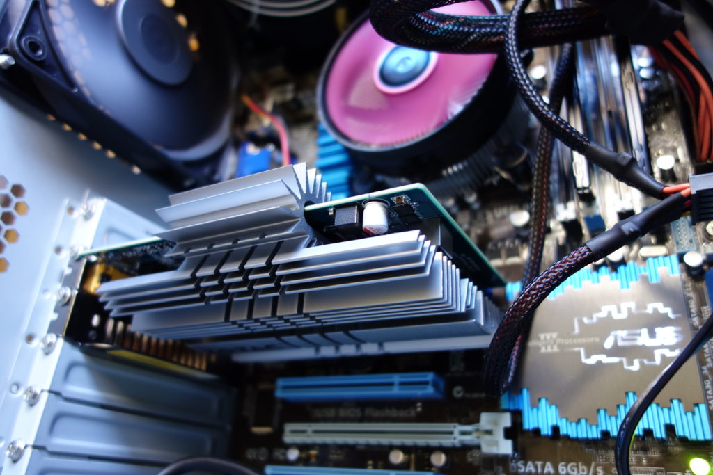 自作PCの内部を撮影した写真。 様々な部品やケーブルが見える。 写真中央にはファンレス ヴィデオ カードのGeForce GT 240 1GB ZONE Editionが写っている。