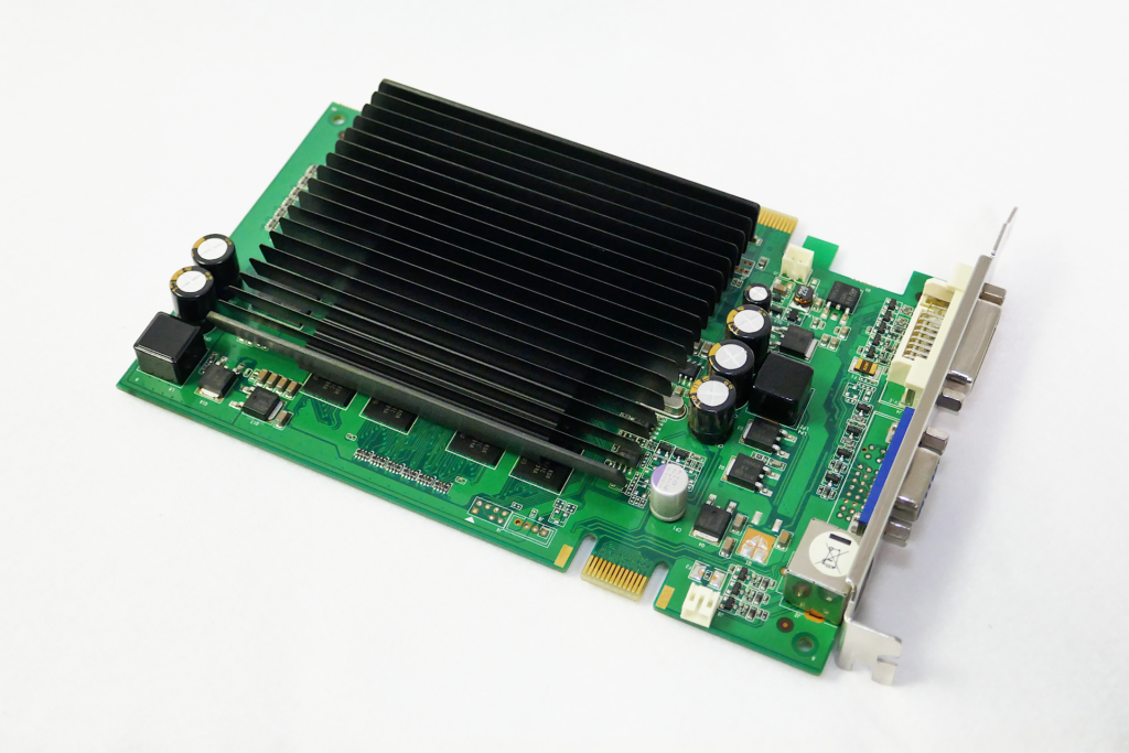 Palitのファンレス ヴィデオ カードであるGeForce 9400GT Superを撮影した写真。 黒色の多数の板が連なった形状のヒート シンクが搭載されている。 ブラケットを右下側にして置かれている。