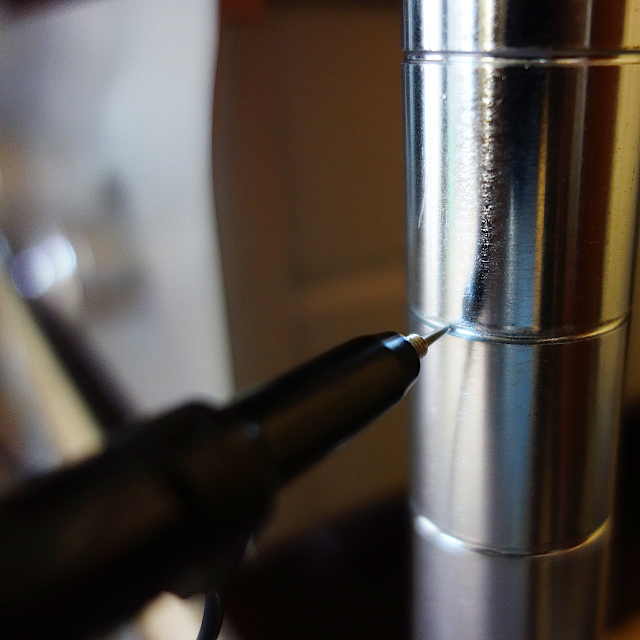 AVラックの金属ポールのくびれ部分にオシロスコープのプローブの先端を当てているところを撮影した写真。