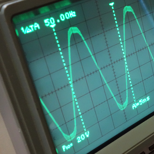オシロスコープの画面の写真。 正弦波のノイズ波形が映し出されている。 周波数は50Hzと表示されている。