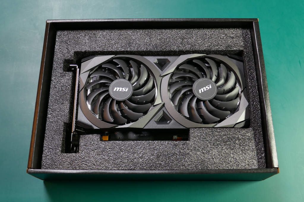 箱に収められたMSI GeForce RTX 3060 VENTUS 2X 12G OCグラフィクス カードを撮影した写真。黒色の緩衝材に囲まれている。